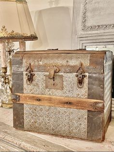 an old trunk sitting on top of a table next to a lamp