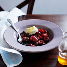 a white plate topped with berries and cream