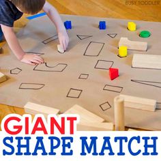 a young boy playing with giant shapes on the floor