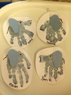 four handprints on the side of a toilet seat with an elephant and giraffe