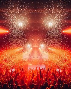 a large group of people at a concert with confetti in the air