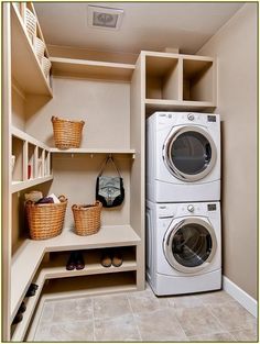 a washer and dryer sitting in a room next to some shelves with baskets on them