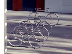 a row of bikes sitting next to each other on top of a parking meter in front of a building