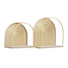 two gold metal bookends with arched arches on each side, one has a white shelf and the other is beige