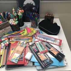 the desk is full of pens, pencils, and other school supplies on it