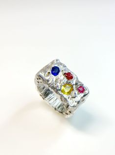 This chunky square band ring is a true work of art. It features four stunning gemstones, including blue and yellow sapphires, pink and red spinels, each carefully selected for its unique beauty and quality. The irregular setting gives the ring a rough texture and contemporary look that is perfect for making a statement. Handmade with love, this ring is a perfect addition to any jewelry collection, whether you wear it every day or on special occasions. As each ring is handmade, no two are exactly alike, making it a truly one-of-a-kind piece of jewelry. Customization is available for those who want to choose their favorite gemstone colors. Please contact me if you have any questions or preferences. This is a ready to ship item！ -Gem Information Ceylon blue sapphire  Ceylon Yellow sapphire Ceylon Blue Sapphire, Red Spinel, Pink Spinel, Rough Texture, Gem Ring, Unique Beauty, Pink And Red, Pinky Ring, Yellow Sapphire