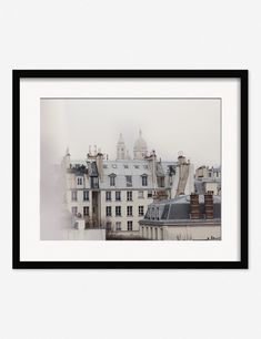 a black and white photo of buildings with rooftops in the foreground, on a foggy day