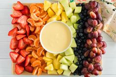 a platter filled with fruit and dip