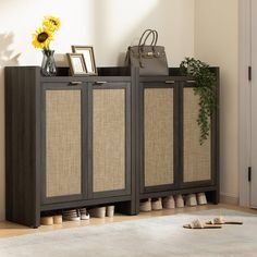 a brown cabinet with baskets and shoes on top of it next to a vase filled with sunflowers