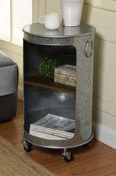 a round metal shelf with magazines on it and a plant in the corner next to it