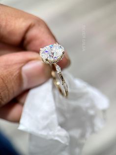 a close up of a person holding a diamond ring