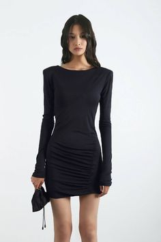 Mini dress with asymmetric front draping and open back. Strapy metal chain element on the back. Long sleeves and detachable shoulderpads. The dress is slimfit and made out of elastic viscose jersey. Material: viscose satin jersey. Model wears size S. Models’ height 177 cm