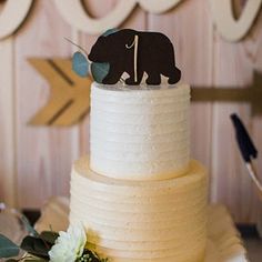 a three tiered cake with an elephant topper