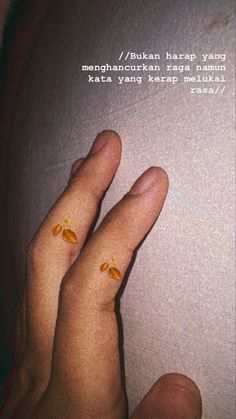 two fingers with yellow flowers on them and an open book in the background that says,