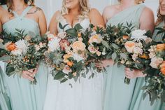 the bridesmaids are holding their bouquets together