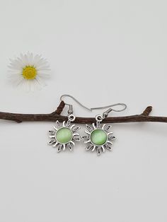 These are elegant silver sun earrings. Stainless steel hooks with alloy charms. You can choose the Sun charm colour (green or pink), it does change colour depending on the lighting.  They are very lightweight. Each pair comes in a small gift pouch.  I hope you will enjoy this pretty pair. * Like most metals, Tibetan Silver (zinc alloy) can tarnish and discolour. To help prevent tarnish, it's best to avoid moist or wet conditions, and when not in use, store in an airtight container (a silica gel Sun Earrings, Celestial Earrings, Sun Charm, Boho Style Jewelry, Earrings Boho, Keep Jewelry, Silver Pieces, Fun Earrings, Beautiful Earrings