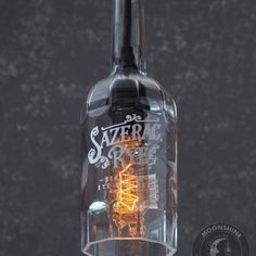 a glass bottle with a light inside of it on a black background, that says sazerd