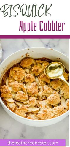 an apple cobbler in a white casserole dish with a spoon on the side