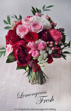 a bouquet of red and pink flowers on a table