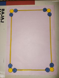 a pink paper with blue and yellow balls on it in the shape of a rectangle