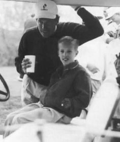 an old photo of a man and a boy sitting on a boat with drinks in their hands