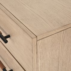 a wooden dresser with black handles and drawers