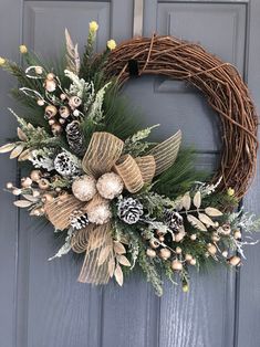 a wreath on the front door with pine cones and other decorations hanging from it's side