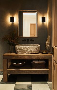 a bathroom sink sitting under a mirror on top of a counter next to a wooden door