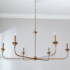 a chandelier hanging from the ceiling in a room with white walls and flooring