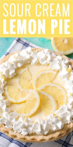 a lemon pie with whipped cream on top and sliced lemons in the background text reads sour cream lemon pie