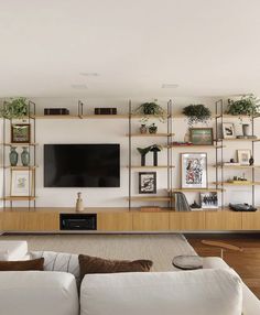 a living room filled with furniture and a flat screen tv mounted on a wall above it