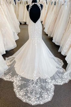 the back of a wedding dress on display in a bridal shop with other dresses