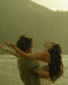 a man and woman are hugging on the beach