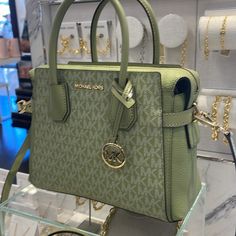 Michael Kors Mercer Small Top Zip Belted Satchel Crossbody Handbag Bag Shoulder Light Sage Nwt Authentic Length: 10.75 Inches (L) Height: 8 Inches (H) Depth: 4.25 Inches (D) Size: Small (S) Strap Length: 3.25 Inches Adjustable From 19.25 Inches To 23 Inches 100% Authentic Features: Gold / Silver Tone Hardware Coated Canvas Michael Kors Logo At Front Gold Toned Hardware Mk Charm On Front Back & Front Slip Pockets Zip Top Closure Custom Mk Fabric Lining Middle Zipper Compartment 2 Slip-In Pockets Cute Purses Michael Kors, Pretty Tote Bags, High End Handbags, Purse Michael Kors, Luxury Bags Collection, Mk Purse, Michael Kors Mercer, Mk Handbags, Michael Kors Logo