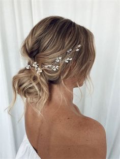 a woman with blonde hair wearing a white dress and a flower headpiece in her hair