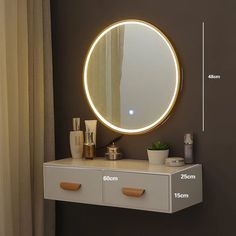 a bathroom vanity with a round mirror on the wall above it and a plant next to it