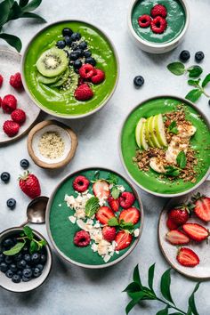 various bowls filled with different types of fruits and vegetables on top of a white table