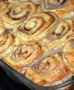 cinnamon rolls are being baked in a glass baking dish