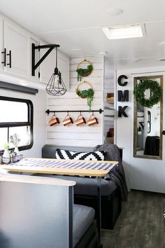 the interior of a mobile home with white walls and wood flooring is decorated in black and white