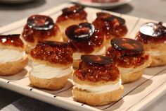 small pastries are arranged on a plate with sauces and toppings in the middle