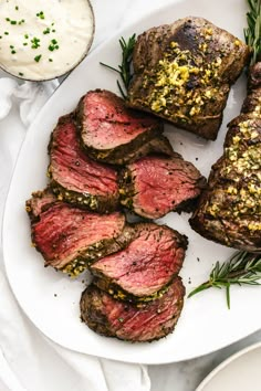 sliced steak on a plate with herbs and ranch dressing