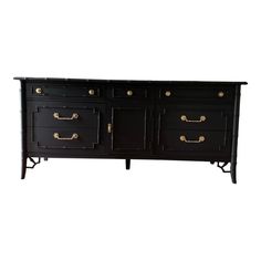 a black dresser with gold handles and drawers