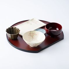 a wooden tray with bowls and spoons on it