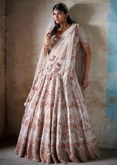 Ivory raw silk bridal lehenga with thread and pearl embroidery paired with two tulle dupattas and an embroidered blouse. Traditional Drape Off White Lehenga For Reception, Wedding Anarkali Set In Raw Silk With Pearl Embroidery, Anarkali Lehenga With Traditional Drape In Beige, Anarkali Lehenga In Beige With Traditional Drape, Anarkali Lehenga In Off White With Dupatta, Beige Anarkali Lehenga With Traditional Drape, Traditional Drape Off White Lehenga For Wedding, Off White Raw Silk Lehenga For Reception, Off White Traditional Drape Lehenga For Wedding