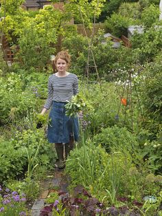 a woman standing in the middle of a garden