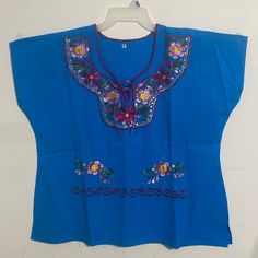 Artisanal Mexican Blouse Color Turquoise Whit Beautiful Embroidered Pink And Burgundy Flowers Sisexl .27” Long From Shoulder To Bottom And 26.6” Chest. New No Tags. Light Blue Short Sleeve Top With Floral Embroidery, Light Blue Embroidered V-neck Top, Blue V-neck Top With Floral Embroidery, Traditional Blue Short Sleeve Blouse, Light Blue Floral Embroidery Tops For Vacation, Blue V-neck Embroidered Top For Beach, Blue Floral Embroidery Beach Tops, Blue Floral Embroidery Top For Vacation, Blue Cotton Embroidered Short Sleeve Top