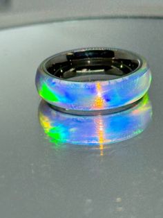 This ring is a size 7.5 stainless steel band 1/4 wide with synthetic lab grown opal on the outside. This is what I would call a white opal reflects like a aurora borealis with green/and other reflective properties you name it it's in there. I bought the blank and turned it on the lathe. polished to a high gloss. The blank alone for one ring was 30 dollars since this is very expensive to make is why the high price. But we'll worth it after seeing it. Iridescent Opal Ring With Gemstone, Iridescent Opal Ring For Gift, Handmade Iridescent Opal Ring Gift, Handmade Iridescent Opal Ring, Opal Ring Wedding, Iridescent Opal Round Jewelry, Opal Band Ring, Food Spread, Opal Band