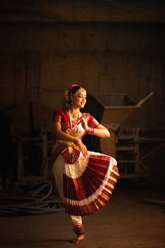 a woman in a red and white dress is dancing