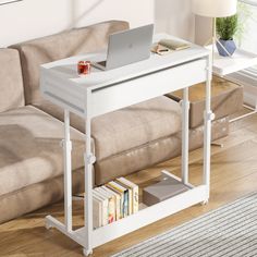 a laptop computer sitting on top of a white table next to a couch and coffee table