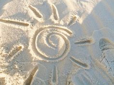 the sun is drawn in the sand and it appears to be made by someone's hand